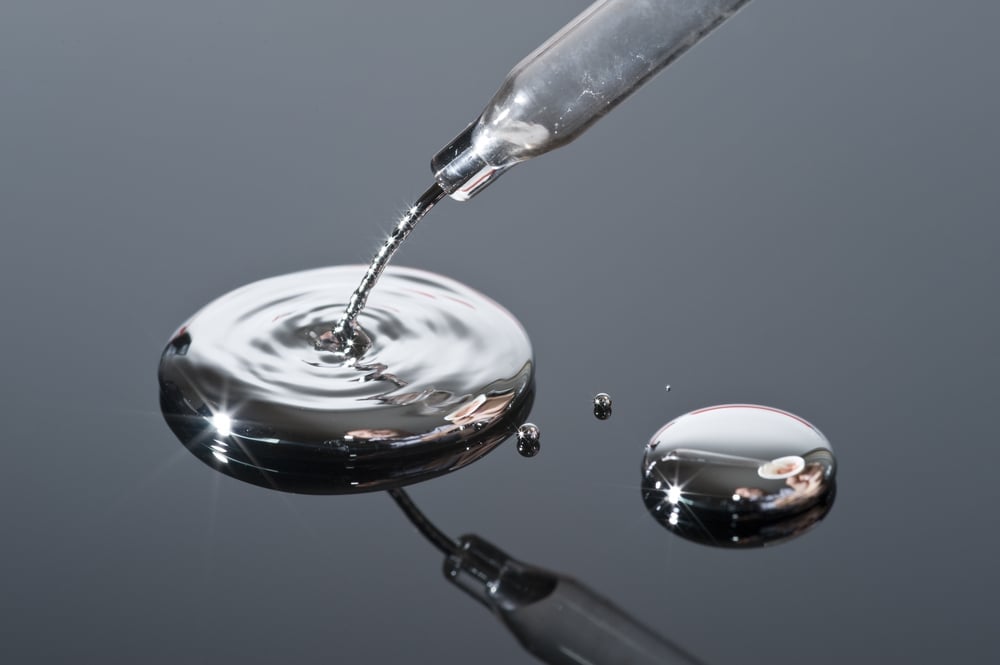 Mercury pouring from a pipette onto a reflective surface(MarcelClemens)s