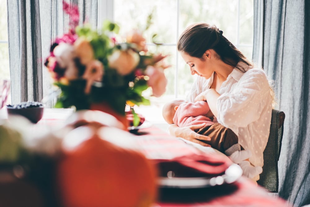 young-woman-with-long-dark-hair-breastfeeding-baby-AAT5WWM