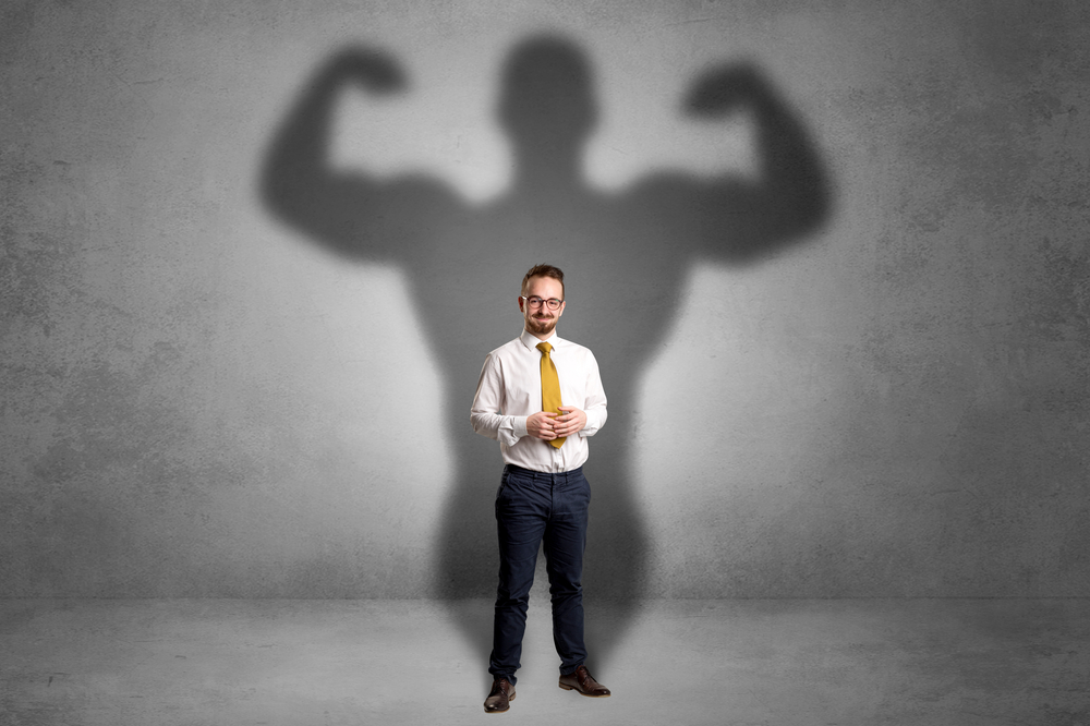 Lovely,Serious,Businessman,Standing,With,A,Muscular,Powerful,Shadow,Behind