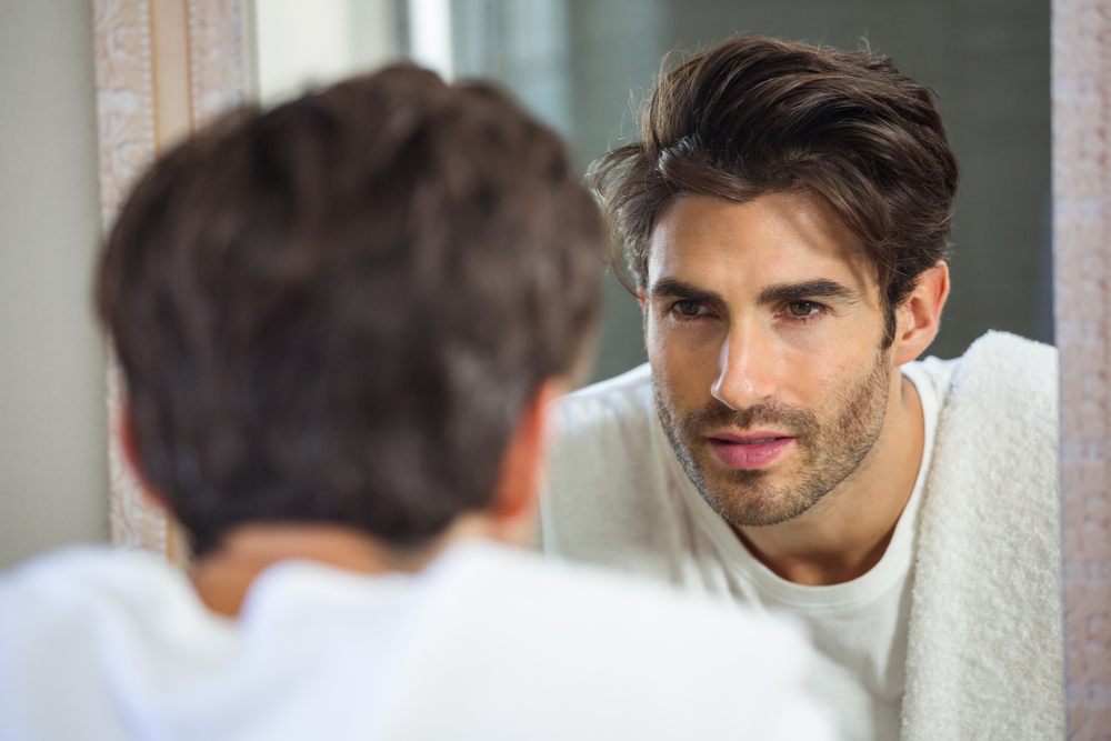 Young,Man,Looking,Himself,In,Bathroom,Mirror