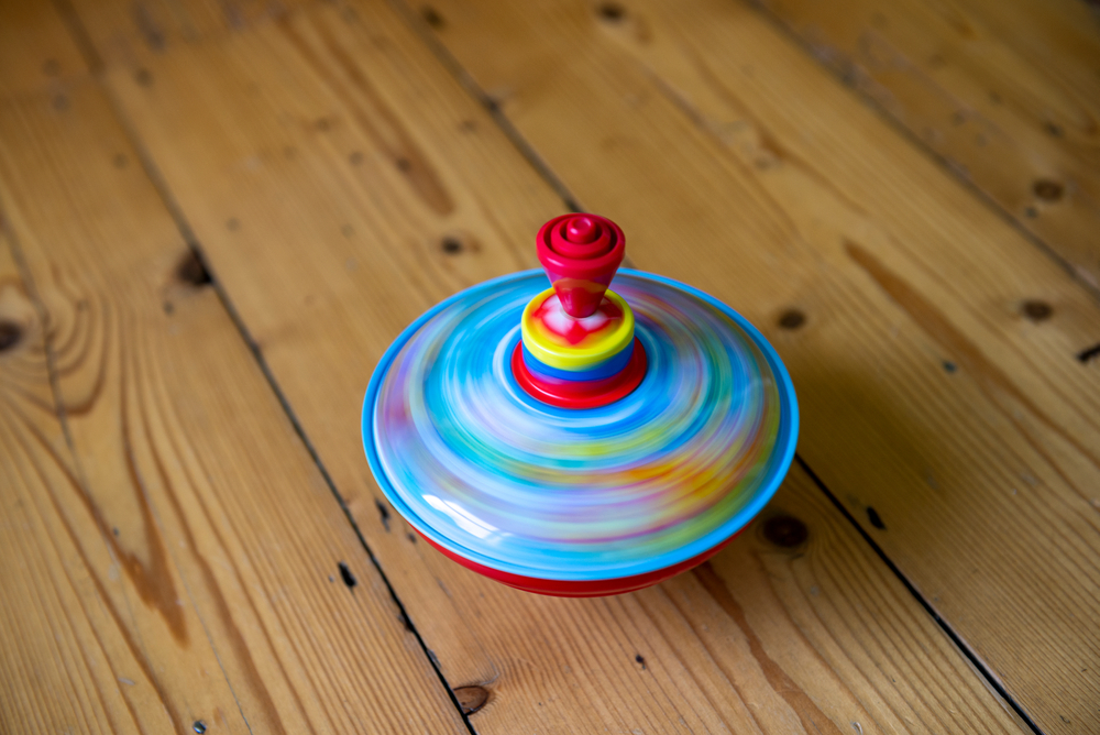 A,Colourful,Spinning,Top,On,A,Wooden,Floor,Spins,Round