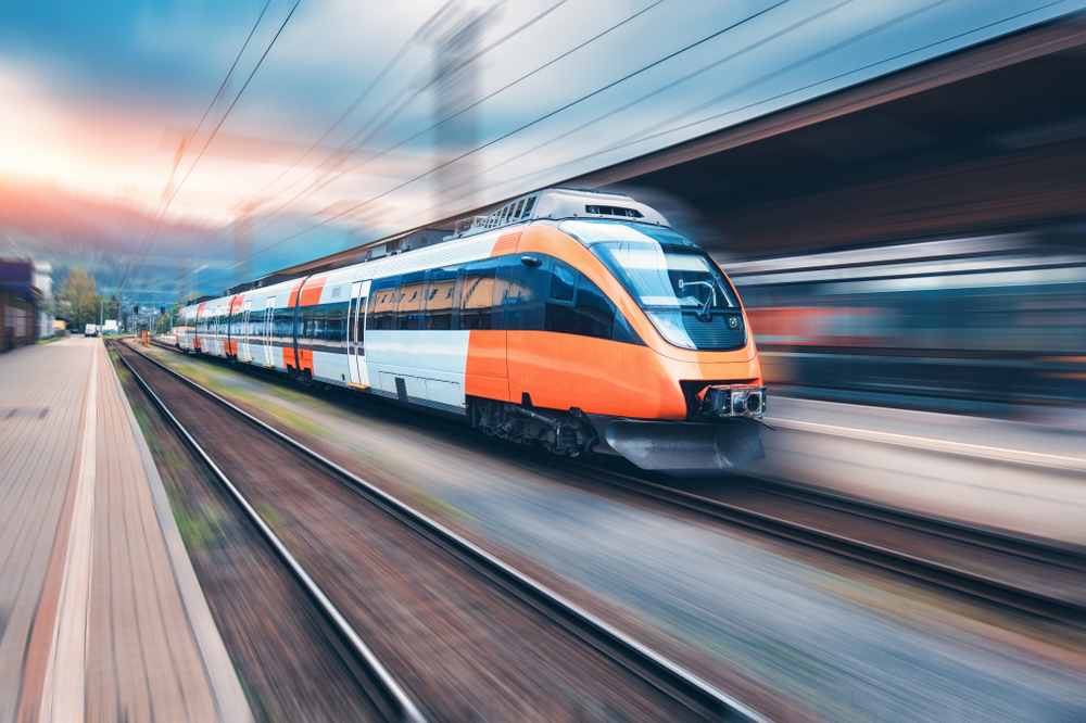 High,Speed,Orange,Train,In,Motion,On,The,Railway,Station