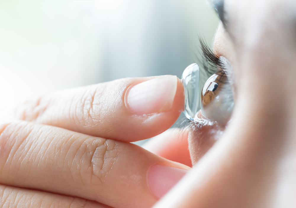 Young,Woman,Putting,Contact,Lens,In,Her,Right,Eye,,Close