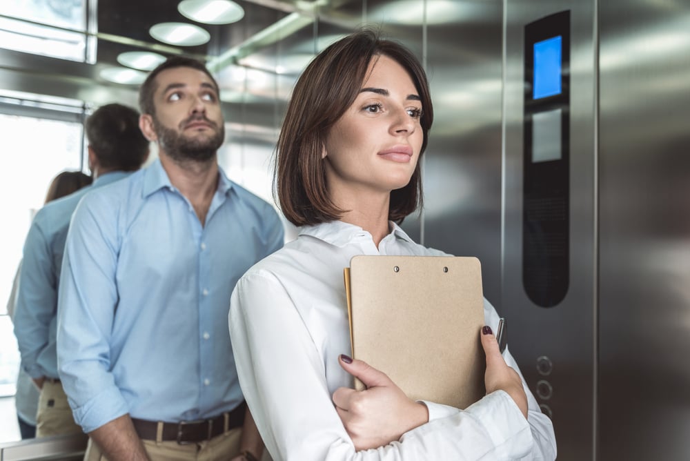 Business couple is rising in elevator