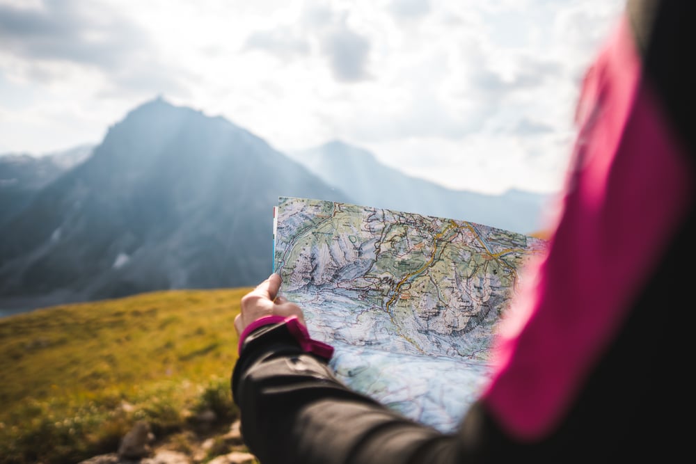Adventurous,Girl,Navigating,In,With,A,Topographic,Map,In,The