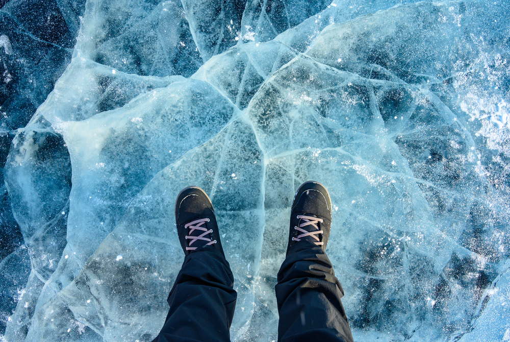 A,Foot,Of,Tourist,Standing,On,The,Cracks,Surface,Of