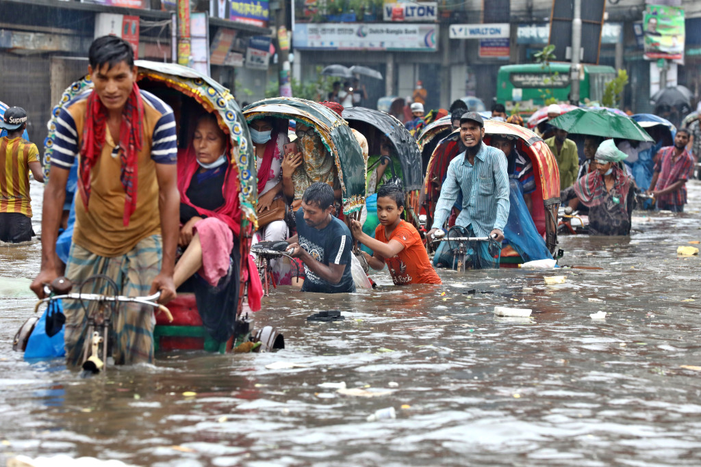 Dhaka, Bangladesh - July 21, 2020 Vehicles try to drive through a flooded street in Dhaka.