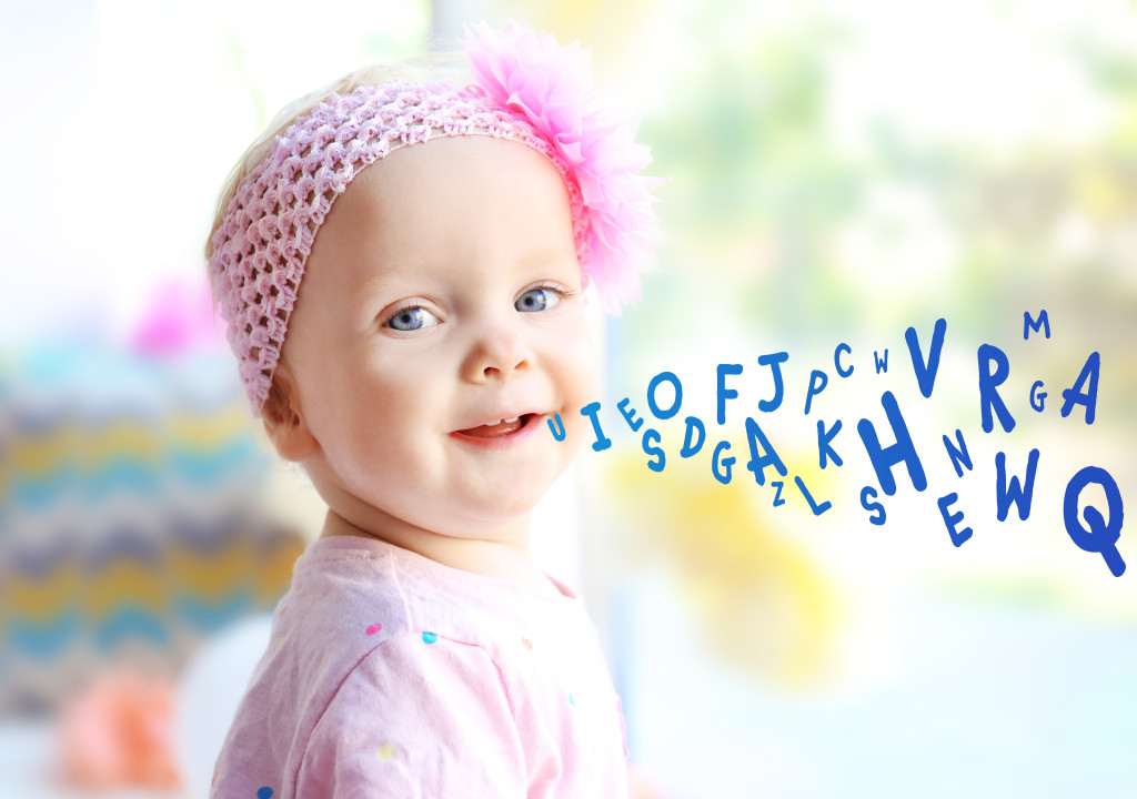 Little girl and alphabet letters on background. Speech therapy concept
